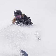 Abby snowboarding in deep powder